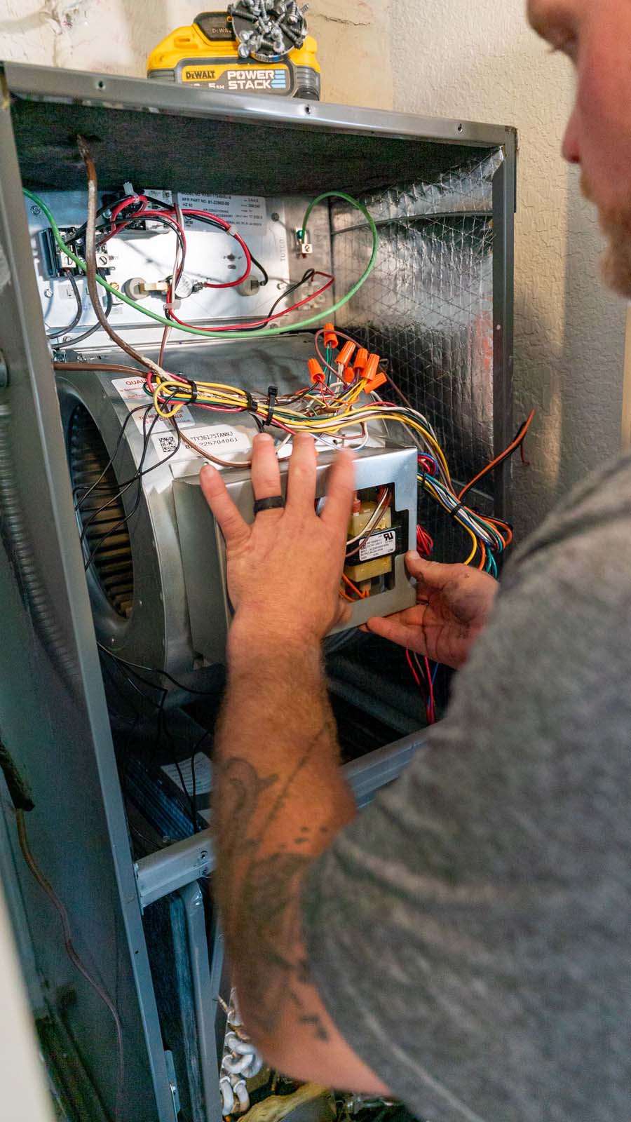 A man looking at wires inside interior AC handler