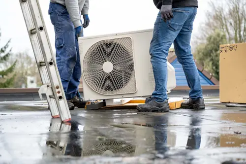 Heat pump being carried by two workers