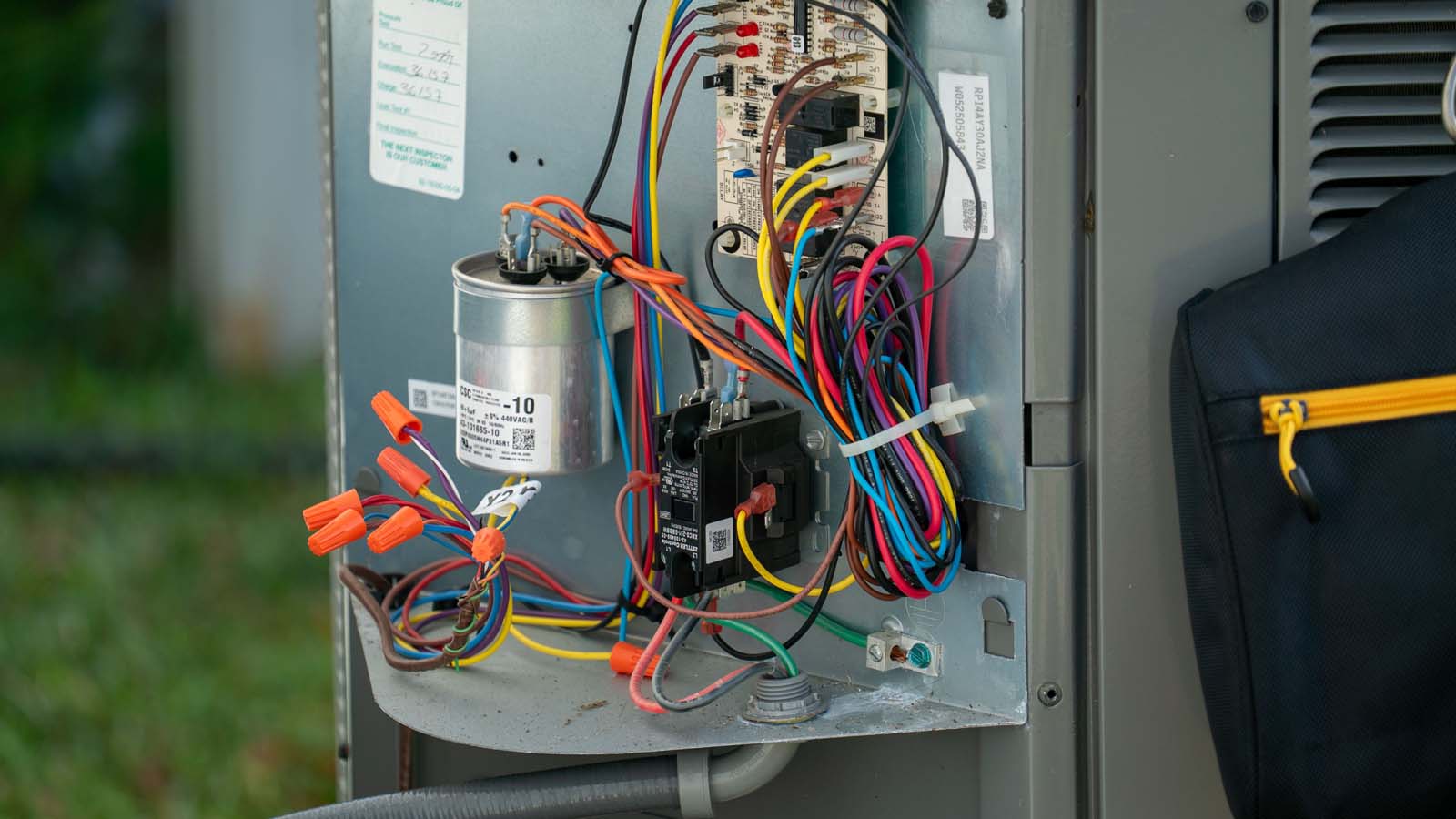 HVAC technician working on outdoor wiring during an emergency AC repair call in Lakeland, FL