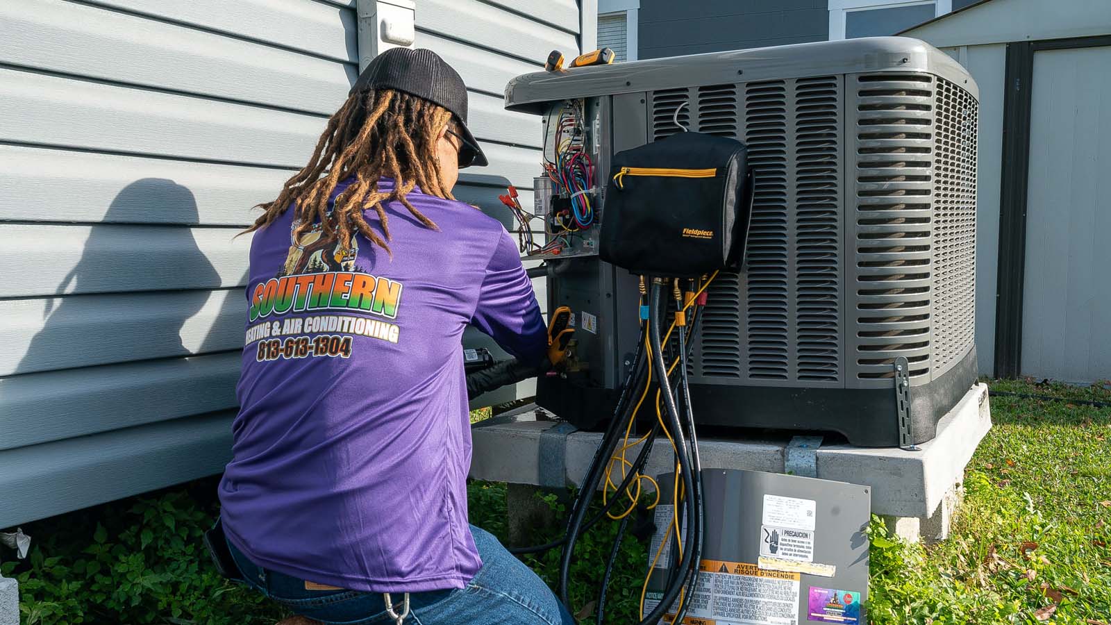 HVAC technician working on an outdoor condenser unit in Valrico, Florida